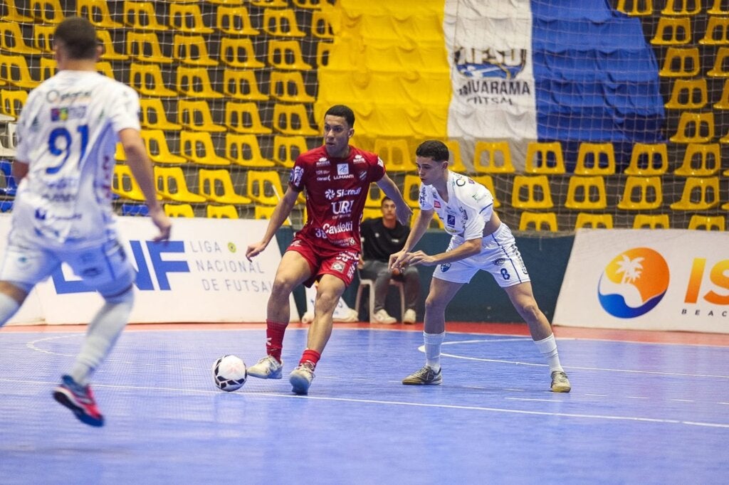 Atletas do Umuarama Futsal e do Atlãntico de Erechim durante disputa de bola.