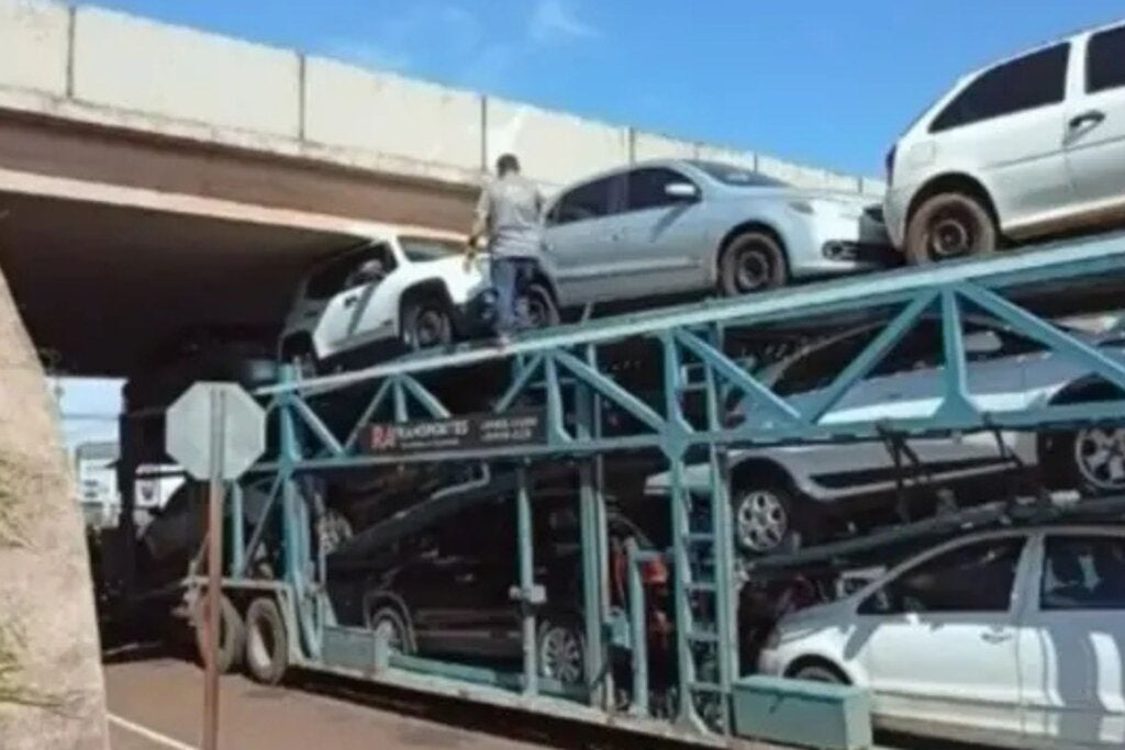 Caminhão-cegonha fica preso sob viaduto da PR-323 após veículo enroscar na estrutura; vídeo