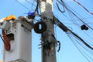 Trabalhador realizando reparo em poste de energia elétrica.