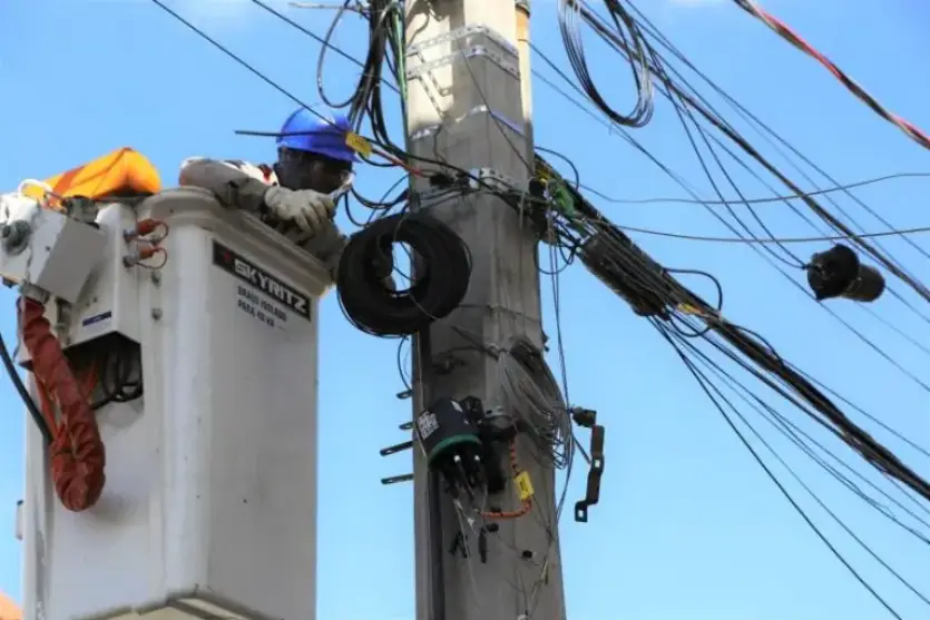 Trabalhador realizando reparo em poste de energia elétrica.