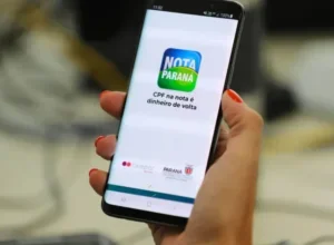 Mão segurando celular com menu do Nota Paraná.