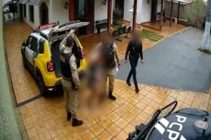 Homem sendo preso após arrepessar bebê no chão.