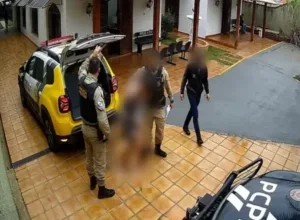 Homem sendo preso após arrepessar bebê no chão.