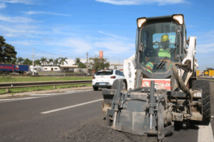 Trecho de rodovia em manutenção com máquina.
