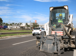 Trecho de rodovia em manutenção com máquina.