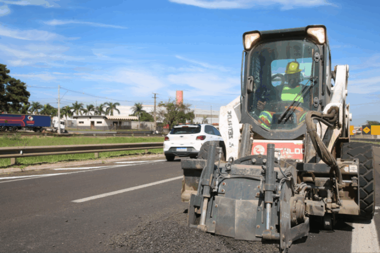 Trecho de rodovia em manutenção com máquina.