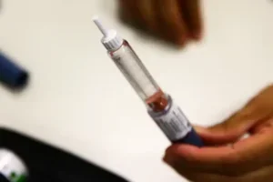 Mão segurando caneta emagrecedora.