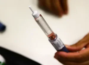 Mão segurando caneta emagrecedora.