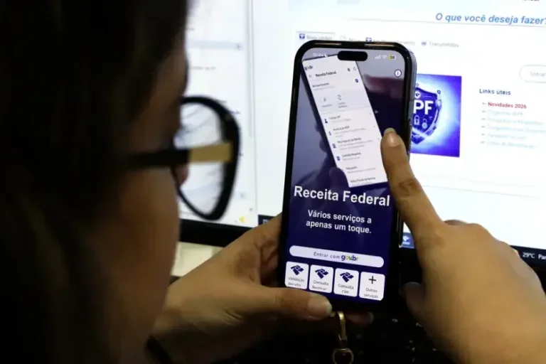 Pessoa usando celular para consultar imposto de renda.