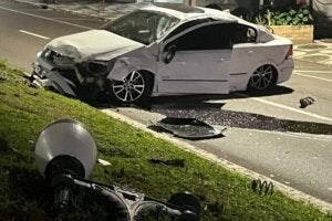 Carro com a frente destruída e um poste em queda em Umuarama.