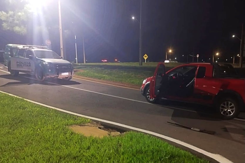 Carro recuperado ao lado de viatura da Polícia Ambiental.