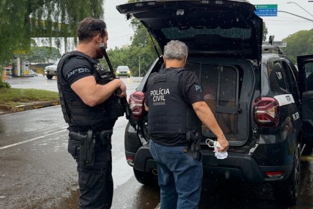 Policiais próximos a um camburão da PCPR.