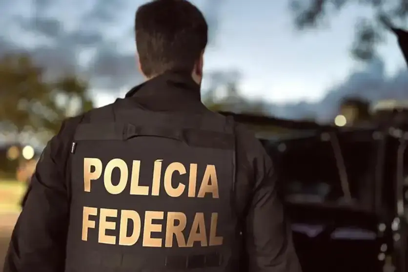 Agente da PF visto de costas.