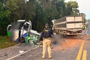 Local de acidente na BR-373, com agente da PRF e ônibus destruído.