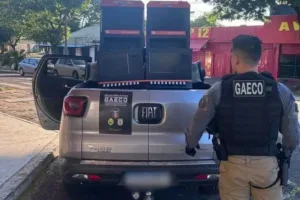 Agente do Gaeco ao lado de máquinas caça-níqueis apreendidas na Operação Alcova.