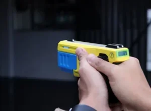 Policial segurando taser.