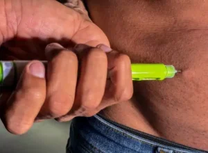 Pessoa aplicando caneta de semaglutida.