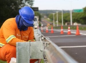Trabalhador realizando serviços de manutenção em rodovia.