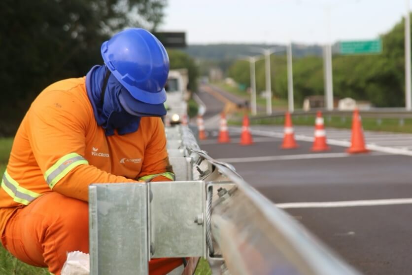 Trabalhador realizando serviços de manutenção em rodovia.