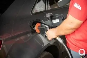 Frentista abastecendo carro em posto de combustíveis.