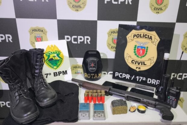 Arma, munição e outros materiais dispostos em uma mesa da PCPR.