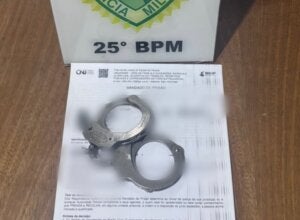 Algema sob um documento de mandado de prisão em Umuarama.