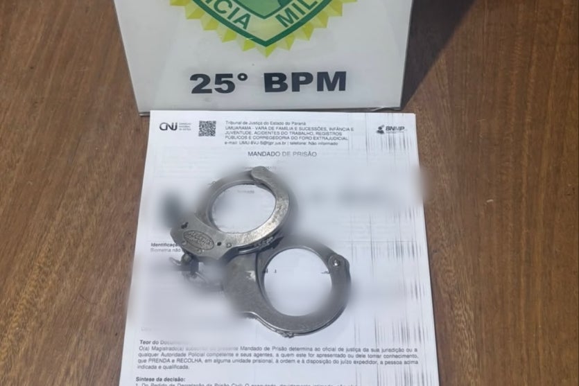 Algema sob um documento de mandado de prisão em Umuarama.
