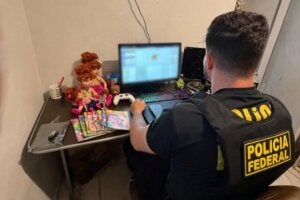 Policial federal verificando notebook.