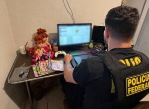 Policial federal verificando notebook.