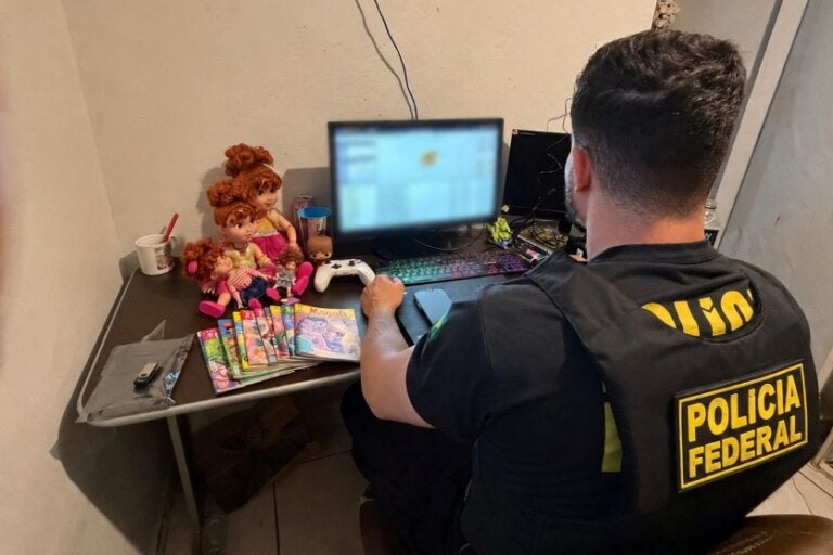 Policial federal verificando notebook.