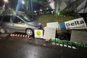 Materiais furtados recuperados pela PM ao lado de um automóvel.