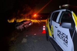 Viatura da PRE próximo a carro envolvido em capotamento na PR-323 em Umuarama.