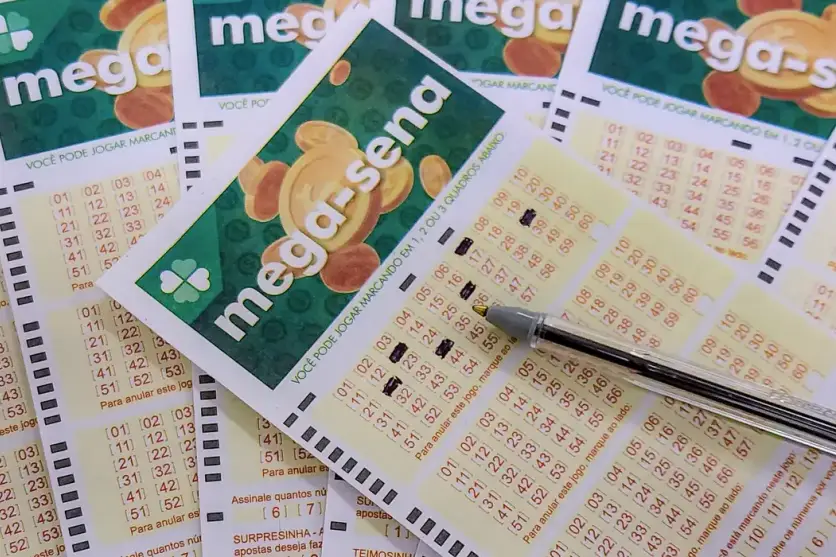 Bilhetes da Mega-Sena espalhado em uma mesa.