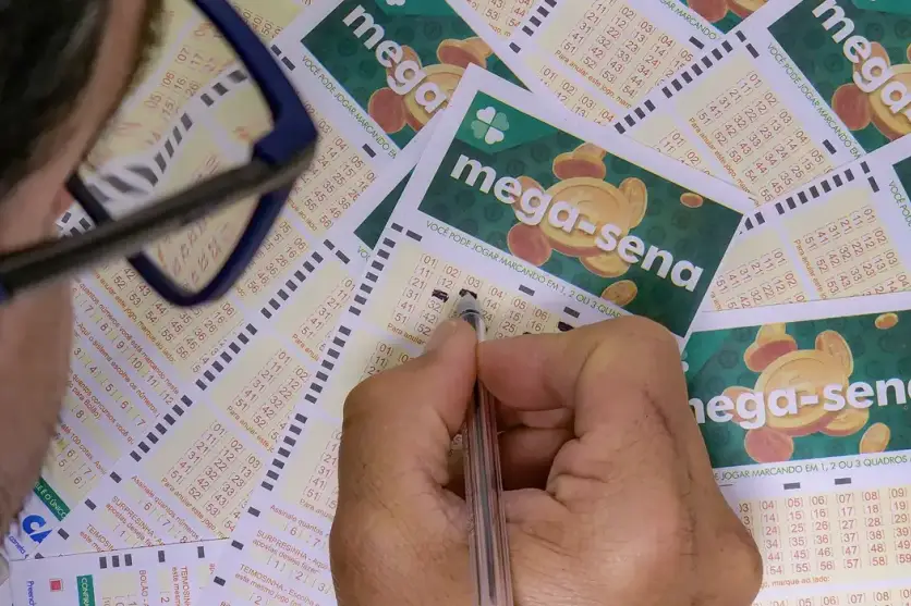 Pessoa preenchendo bilhetes da Mega-Sena.