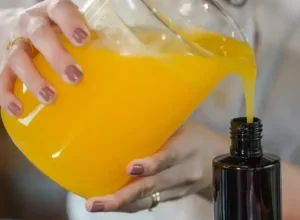 Pessoa preparando um cosmético em um frasco.