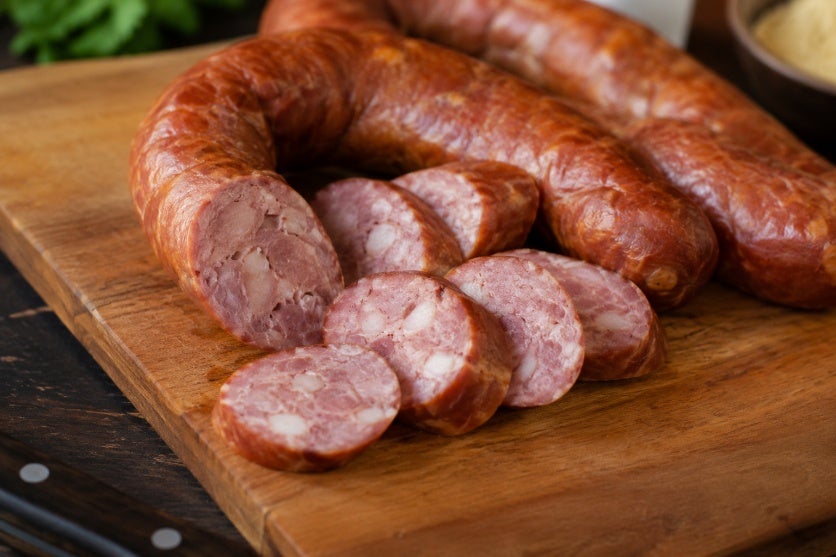 Linguiça defumada em tábua de madeira.