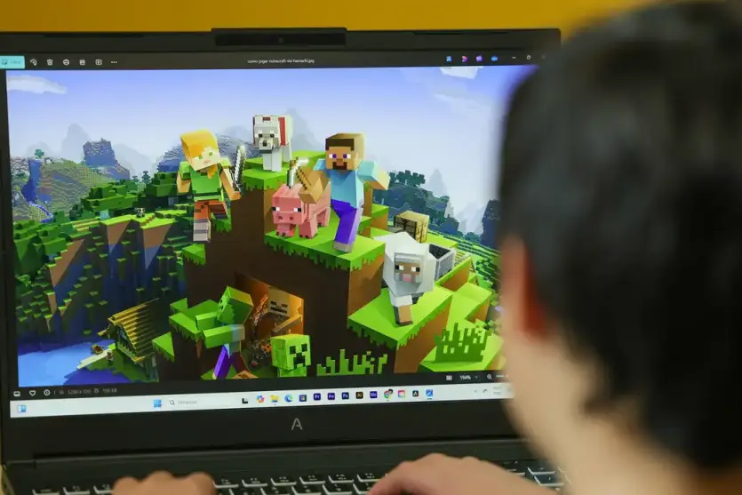 Criança jogando o jogo "Minecraft" em um notebook.