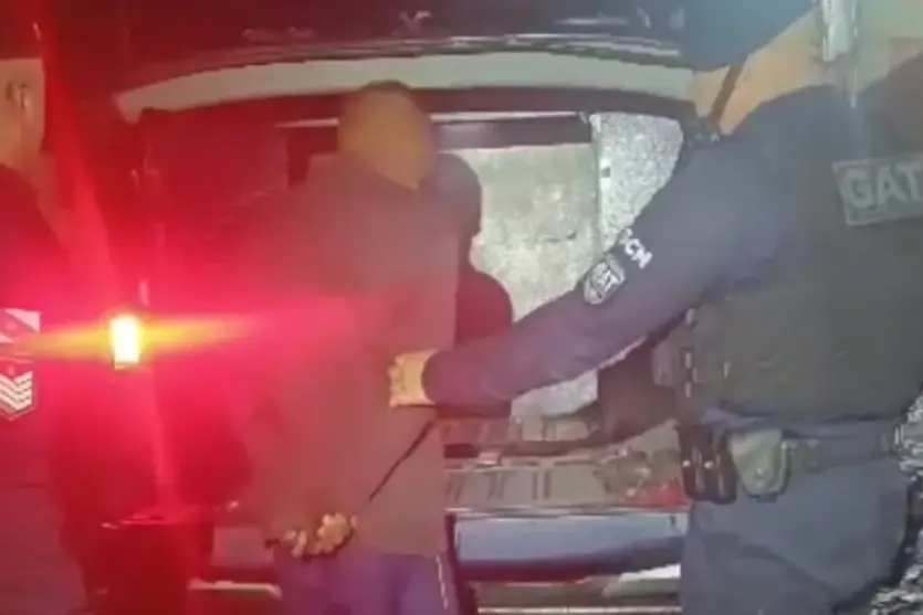 Homem que espirou vizinha pela janela sendo preso por equipes da GMC.