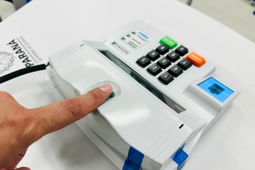 Pessoa checando a biometria antes de votar no primeiro turno das eleições.