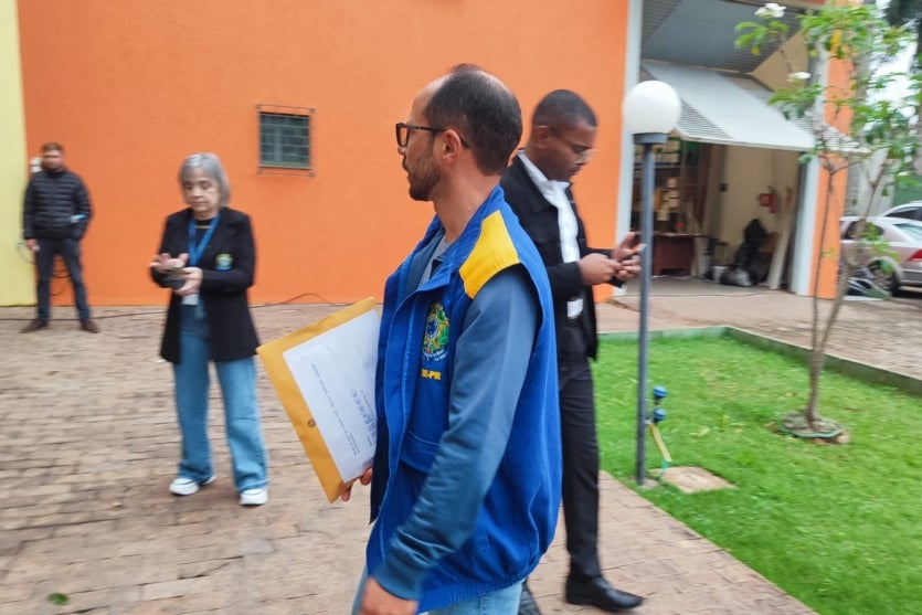 Trabalhador do TSE chegando com envelopes das urnas em Umuarama.