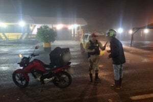 Motociclista realizando teste do bafômetro durante a Operação Padroeira 2026.