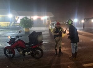 Motociclista realizando teste do bafômetro durante a Operação Padroeira 2026.