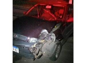 Carro com a frente danificada após colidir contra árvore.