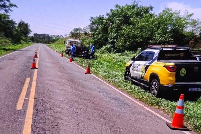 Viatura da PRE próxima ao local onde motociclista colidiu com caminhão.